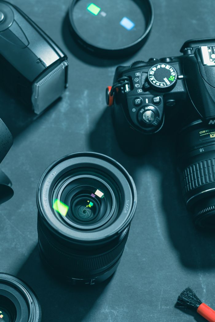 Close-up of DSLR camera and lenses on dark background, highlighting photography gear essentials.